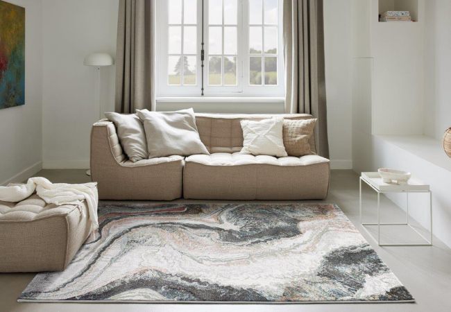 Dywan nowoczesny we wzór marmuru w jasnym salonie z kompletem wypoczynkowym i oknem w tle